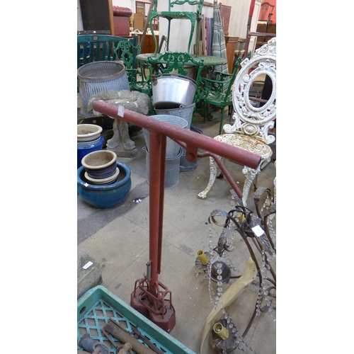 392 - A wrought iron plant stand, a pump, etc.