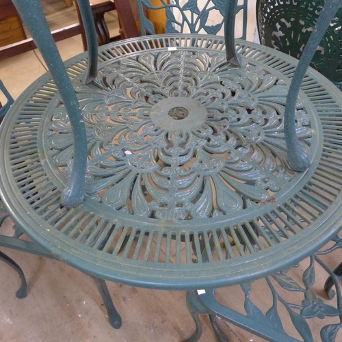 396 - A painted green cast alloy garden table and four chairs