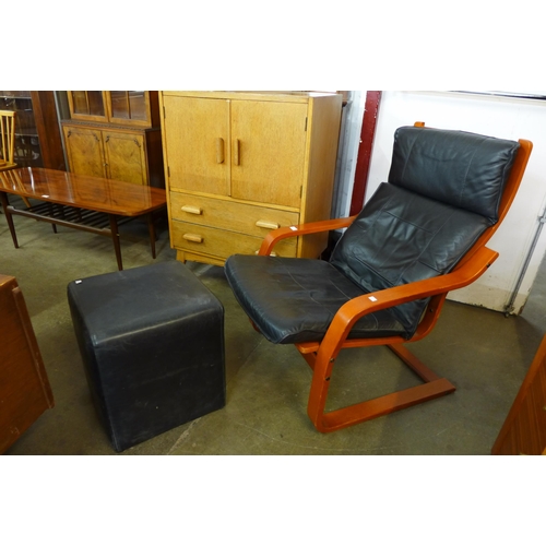 75 - A Scandinavian beech bentwood and black leather cantilever armchair and an ottoman