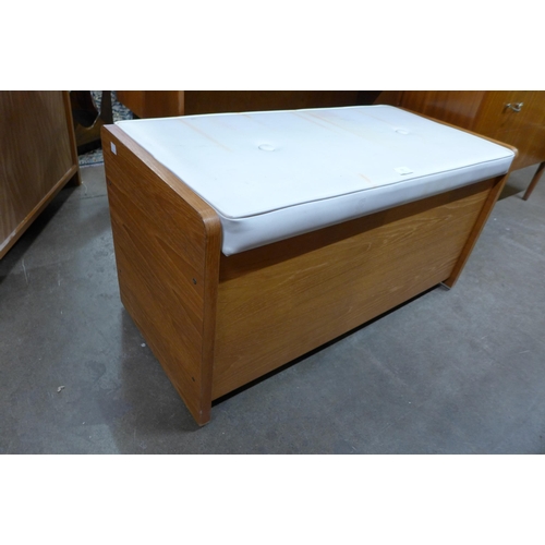 93 - A teak and white vinyl ottoman