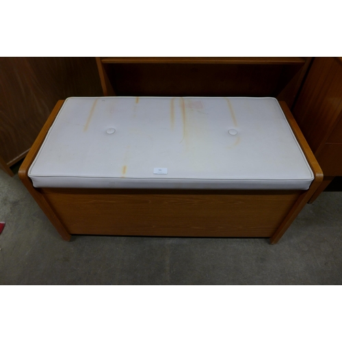 93 - A teak and white vinyl ottoman