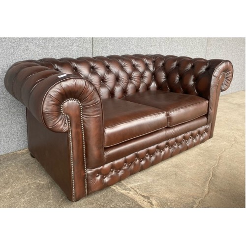 210 - A chestnut brown leather Chesterfield settee