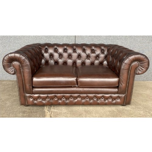 210 - A chestnut brown leather Chesterfield settee