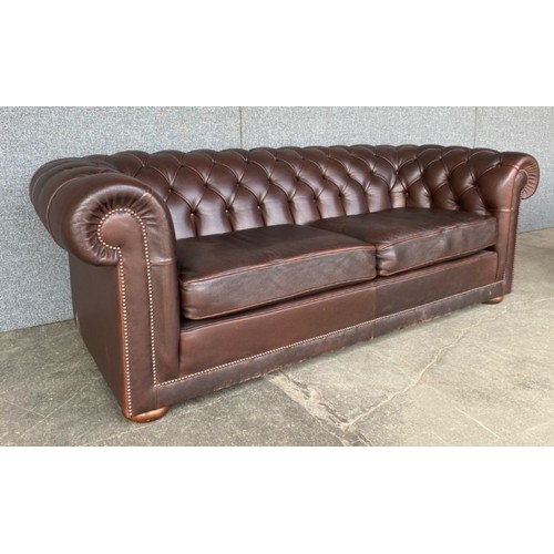 211 - A brown leather Chesterfield settee