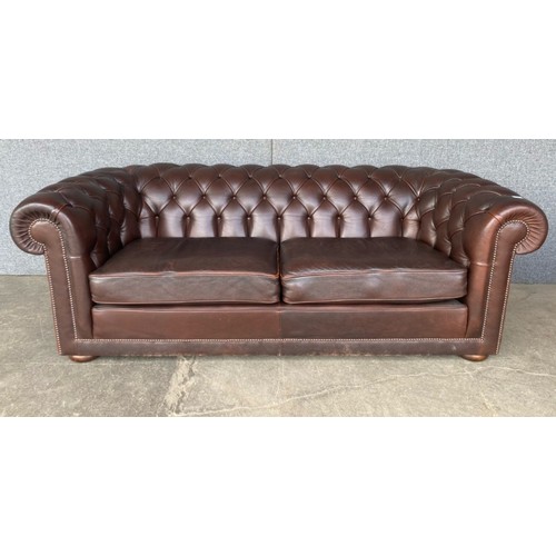 211 - A brown leather Chesterfield settee