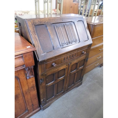 237 - A carved oak linenfold bureau