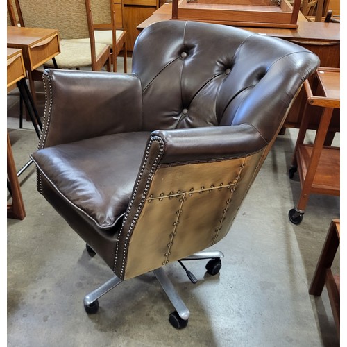 128A - An aviation style brown leather and riveted metal revolving desk chair