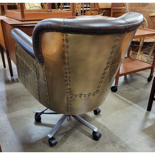 128A - An aviation style brown leather and riveted metal revolving desk chair