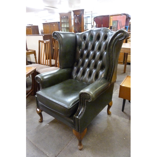 123 - A green leather Chesterfield wingback armchair