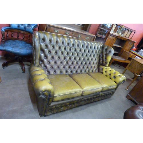 126 - A green leather Chesterfield wingback settee