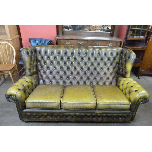 126 - A green leather Chesterfield wingback settee