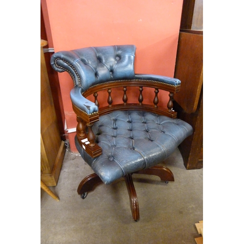 128 - A mahogany and blue leather revolving Captains desk chair