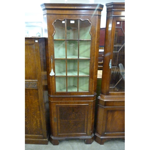 134 - A burr walnut freestanding corner cabinet