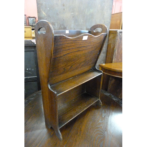 157 - A small oak bookcase/newspaper rack