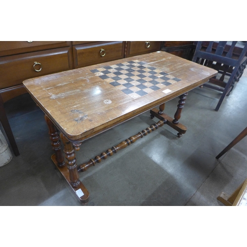 225 - A Victorian inlaid mahogany games stretcher table