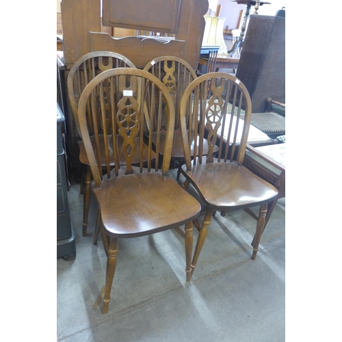 229 - A set of four beech wheelback kitchen chairs