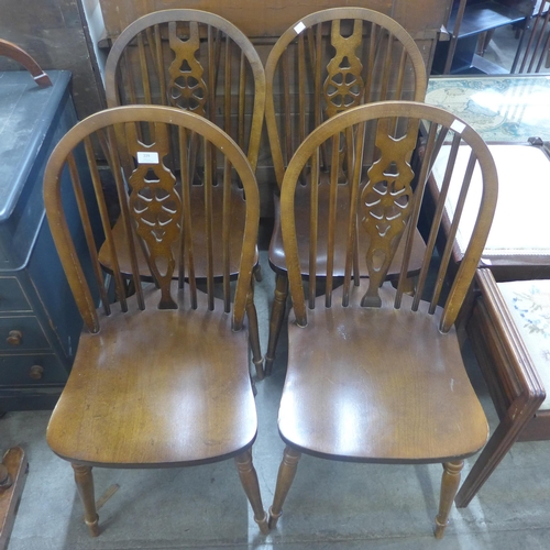 229 - A set of four beech wheelback kitchen chairs