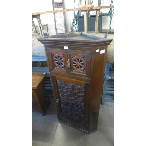 243 - A Victorian Aesthetic Movement carved walnut splay front wall hanging corner cupboard