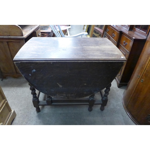 269 - An oak barleytwist gateleg table, a pine desk and a carved oak occasional table