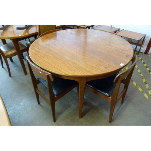 81 - A circular teak extending dining table and four chairs