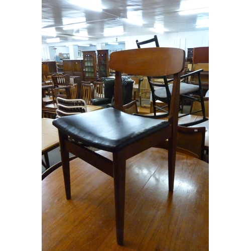 81 - A circular teak extending dining table and four chairs