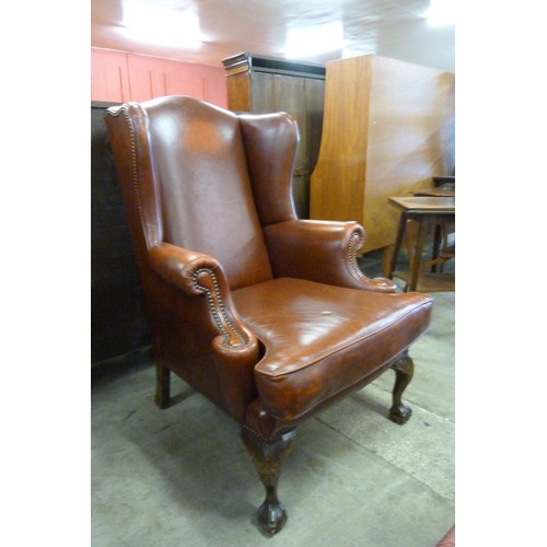 161 - A Queen Anne style brown leather wingback armchair