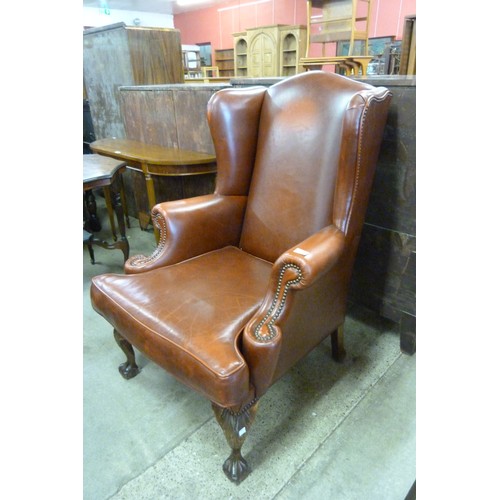 161 - A Queen Anne style brown leather wingback armchair