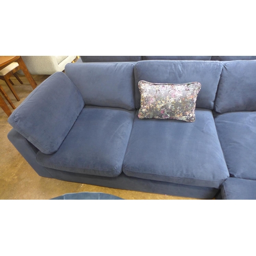 1476 - A large blue velvet six seater corner sofa