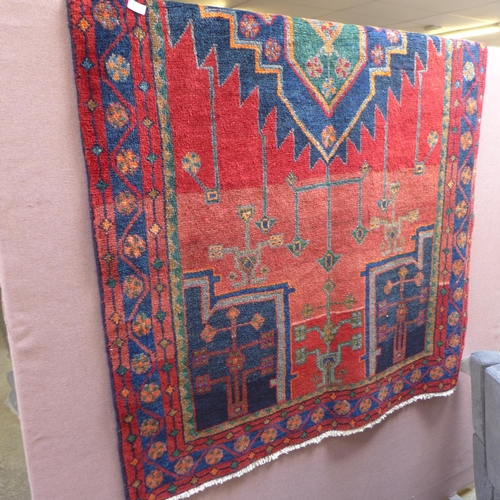 1557 - A rich red and blue ground Persian Hamadan village rug, 254cm x 132cm