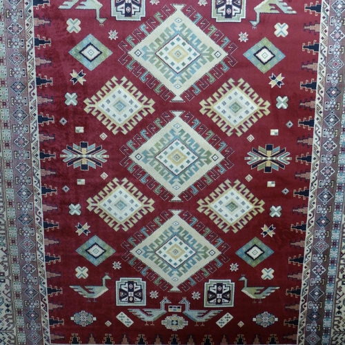 1443 - A Royal Palace red ground diamond medallion rug, 195cm x 135cm