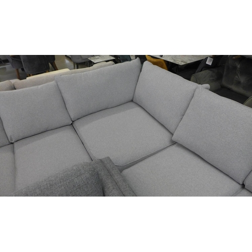 1427 - A grey textured weave upholstered six seater corner sofa, slight damage to arm