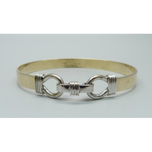 1014 - A yellow and white metal bangle, 16.6g, tests as 9ct gold