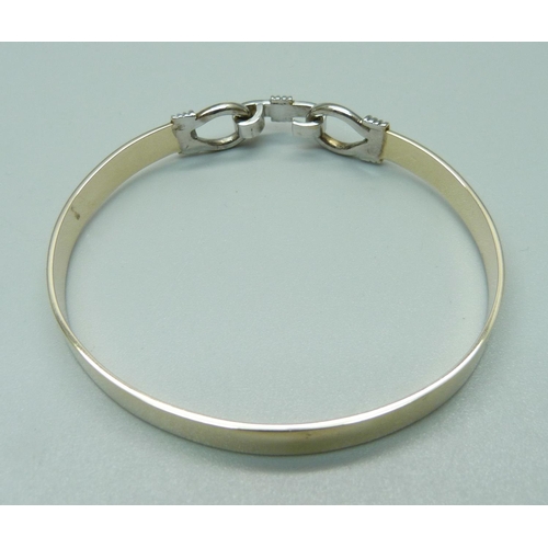 1014 - A yellow and white metal bangle, 16.6g, tests as 9ct gold