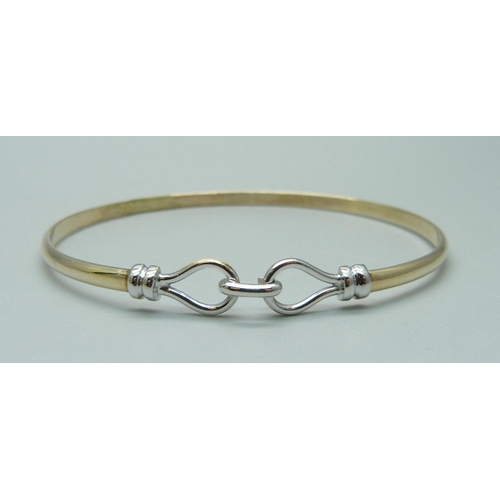 1016 - A yellow and white metal bangle, 8.5g, tests as 9ct gold