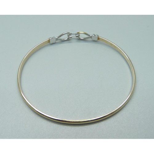 1016 - A yellow and white metal bangle, 8.5g, tests as 9ct gold