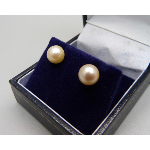 1069 - A pair of 9ct gold, cultured pearl stud earrings, mounts test as 9ct gold