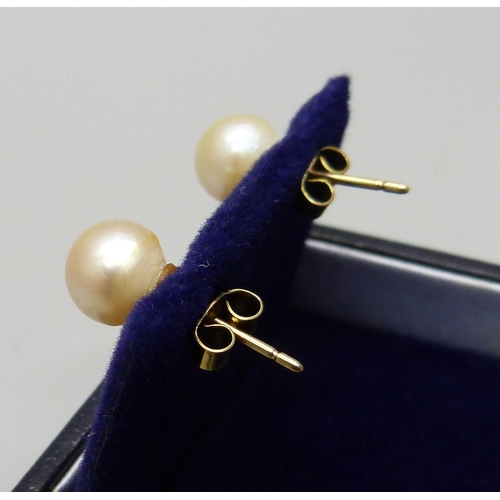 1069 - A pair of 9ct gold, cultured pearl stud earrings, mounts test as 9ct gold