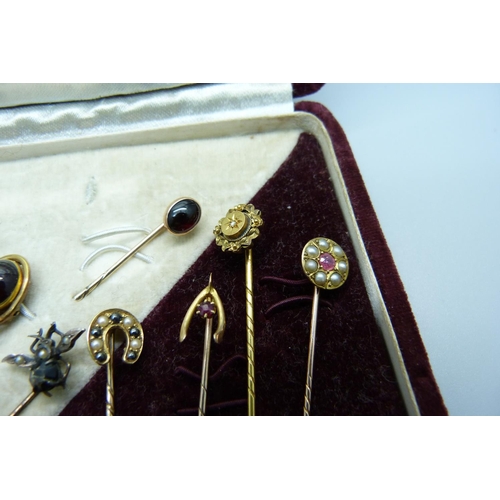 1082 - A collection of eleven pins; one 15ct gold and set with a small diamond, one 9ct gold and set with t... 