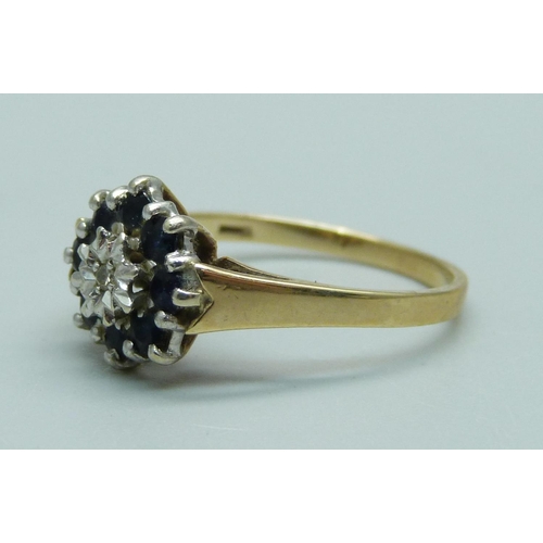 1102 - A 9ct gold ring set with a diamond and sapphires, 1.8g, M