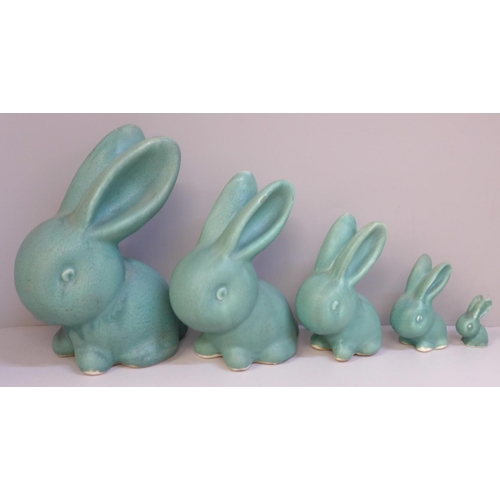 647 - A graduated set of five Bourne Denby rabbits with matt green glaze