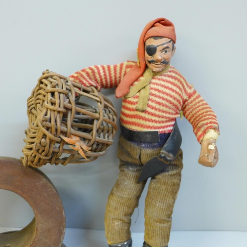 660 - A pocket watch holder made from the teak of HMS Spartiatt and a model of a pirate with crab in lobst... 