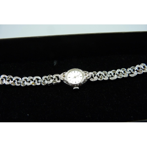 877 - A lady's marcasite cocktail watch, a silver gate bracelet, one other bracelet and a pair of earrings