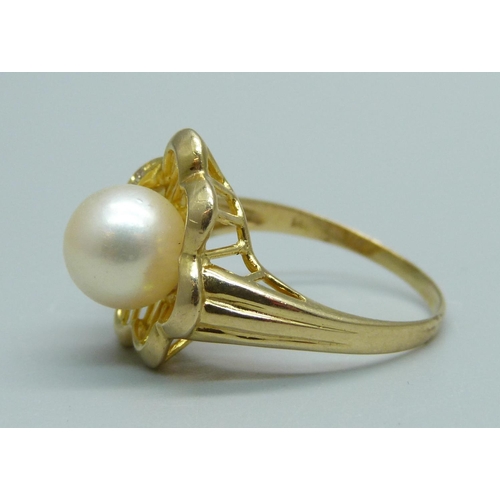 929 - A 14ct gold, pearl and three stone diamond ring, 3.9g, O