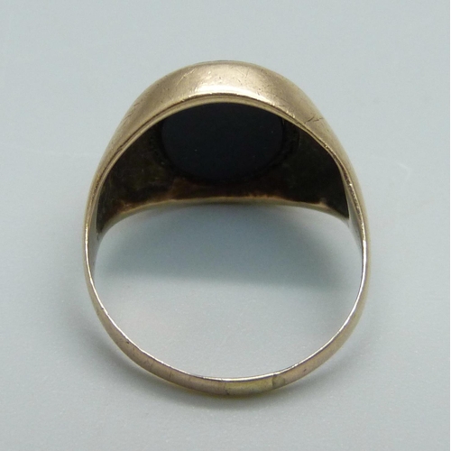 935 - A yellow metal and onyx ring, (tests as 9ct gold), 3.5g, I