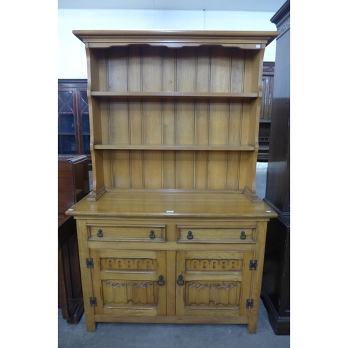 246 - A Kimberley Furniture Ltd. carved oak dresser and an oak wall shelf