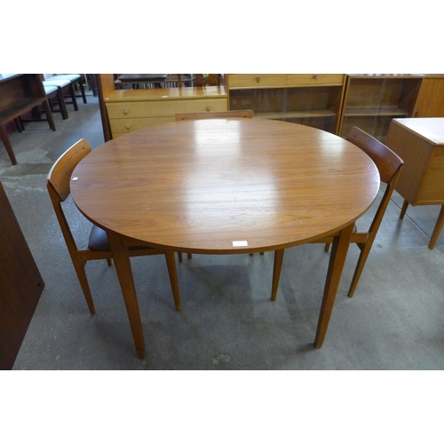 25 - A teak circular extending dining table and four chairs