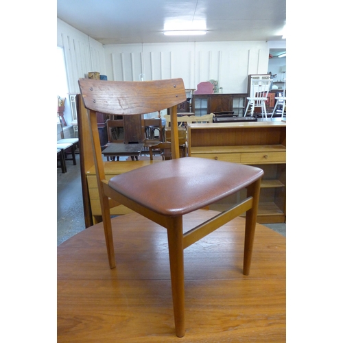 25 - A teak circular extending dining table and four chairs