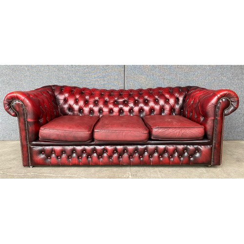 117 - An oxblood red leather Chesterfield settee