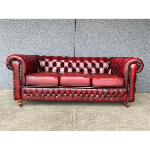 118 - An oxblood red leather Chesterfield settee