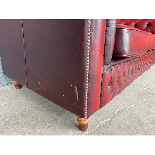 118 - An oxblood red leather Chesterfield settee